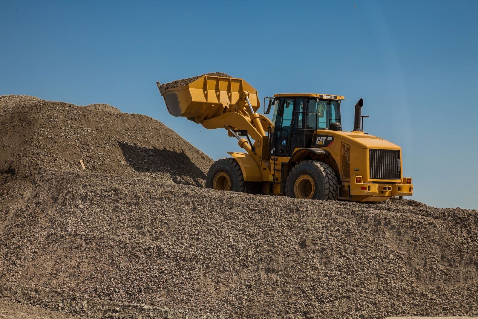 Wheel loader handling material on a stockpile