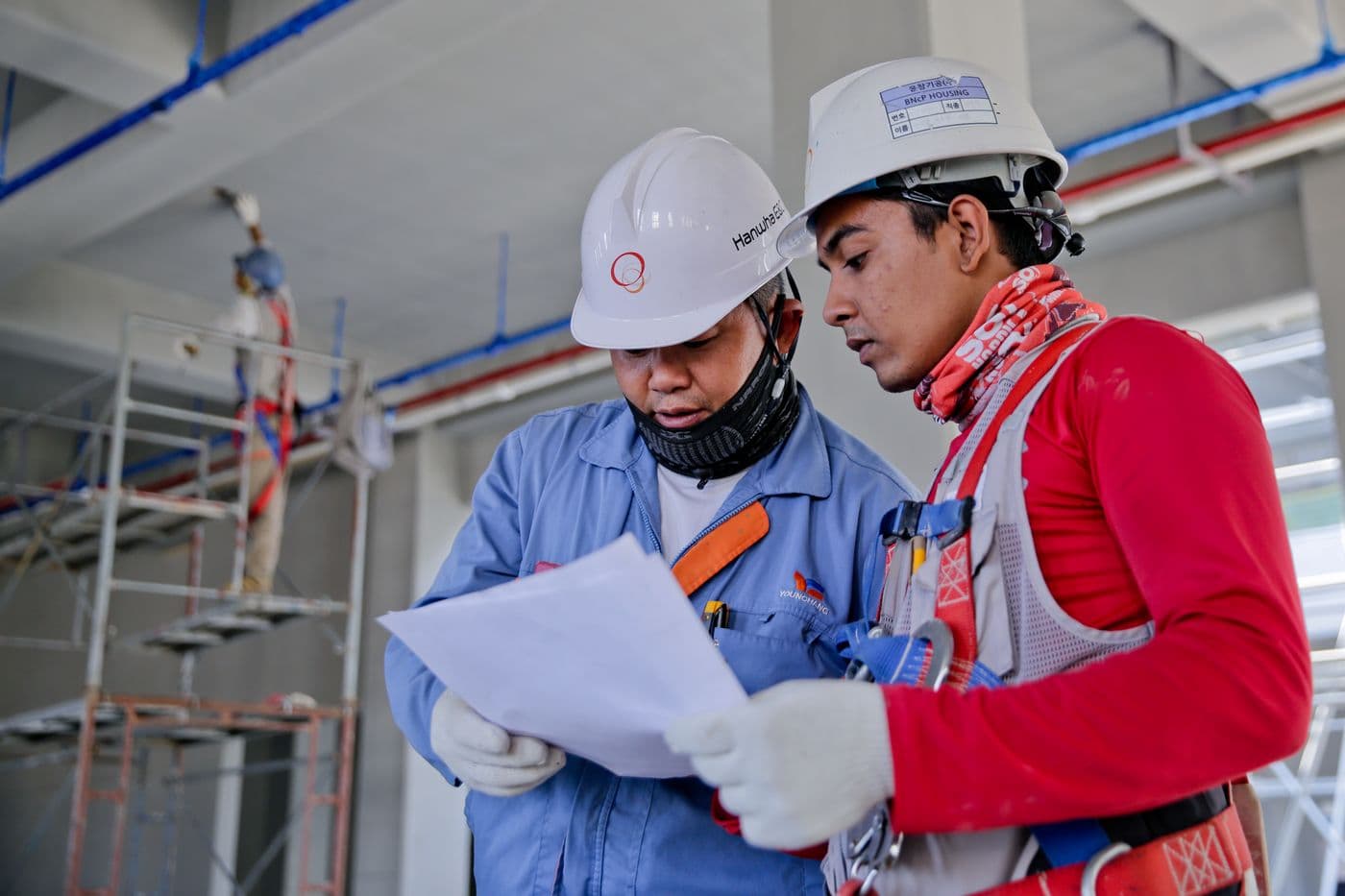 Supervisors in hard hats reviewing a competency brief on site